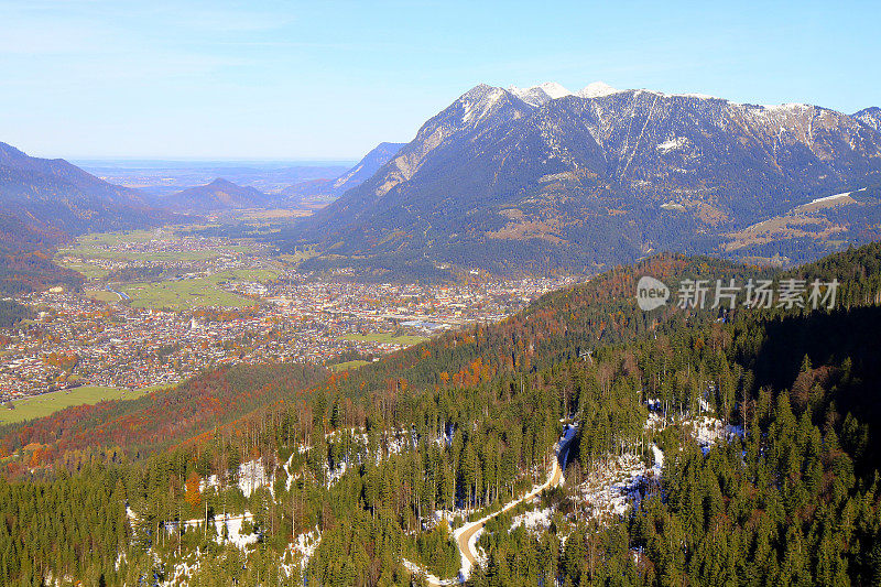 以上Garmisch Partenkirchen阿尔卑斯村在巴伐利亚阿尔卑斯山从Alpspitze，田园诗般的松树林地秋季景观，雄伟的阿尔卑斯山谷，戏剧性的巴伐利亚德国雪山全景，德国